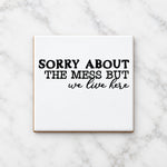 SORRY ABOUT THE MESS BUT We Live Here ceramic coaster in white
